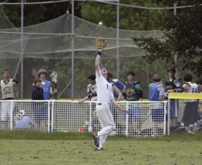 Blake Jensen chases down a fly ball during recent hardball action. The Spartans fell in the first round of tournament play Saturday