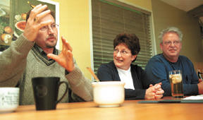 Rob Smith (left) explains his plans for AIDS relief in sub-Saharan Africa to islanders May Fulmer and Marc Fulmer.