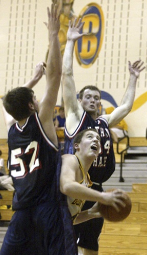 Coby Gibler times his jump beneath a pair of Nathan Hale defenders in Tuesday’s home win over the Raiders.