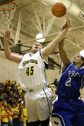 Bainbridge center Coby Gibler is fouled by Seatlle Prep’s Nate Girma on the way to the hoop Friday night. He finished with 10 points and five rebounds as the Spartans beat the Panthers 61-41.