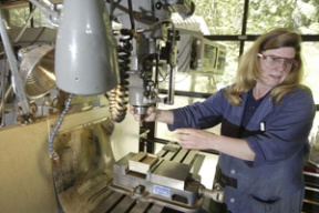 Machinist Helen Maurer demonstrates a drill machine at Browning Research on Day Road.