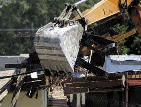 A shattered brick wall is pulled down during demolition work at the Commodore building Thursday morning.