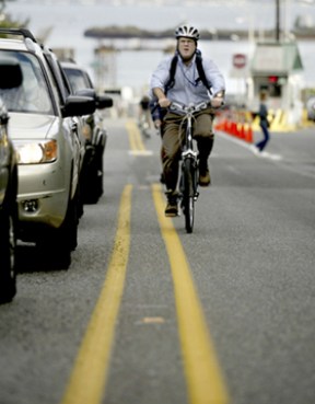 A bicycle commuter crosses the double-yellow line to avoid vehicle traffic exiting the ferry Wenatchee Monday afternoon.