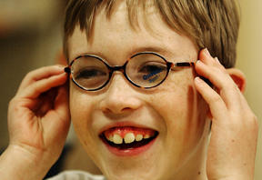 Peter Hutchings puts on pair of glasses that impairs his vision during a class on disabilities at Ordway Elementary School