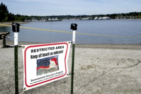 A sign at Pritchard Park on Eagle Harbor’s south shore warns of contaminants recently discovered on the park’s tidelands. Parts of the park were reopened Thursday.