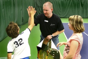 Ross Eaton high fives 8-year-old Peter Sharp and 11-year-old Jenny Russell after a recent practice. The 17-year tennis pro was named the USPTA PNW professional of the year in June.