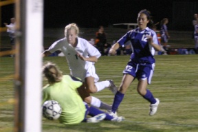 Caitlyn Salo (in white) slips the ball past the North Kitsap keeper for her second goal of the contest