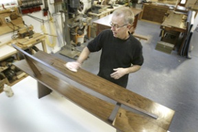 Furniture maker Bob Spangler applies oil to his walnut “Doig” bench