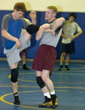 Spartan wrestling coach Dan Pippinger (right) uses a leg lift to demonstrate a takedown on Ian Brooks during practice. The team made a strong showing at a recent tournament in Bellingham.