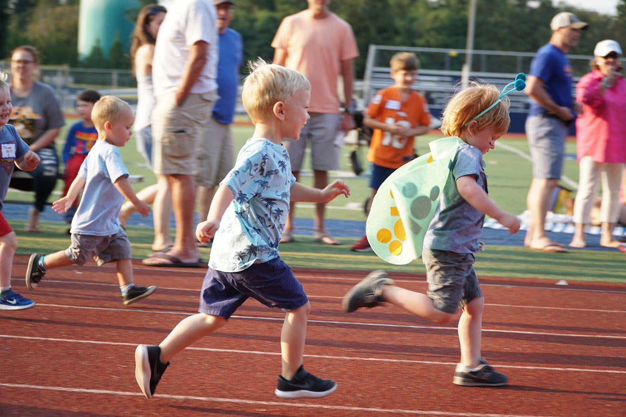 Luciano Marano | Bainbridge Island Review - Young sprinters, one bedecked in a butterfly ensemble, race toward the finish line at the fifth Kiwanis All-Comers Track Meet Monday.