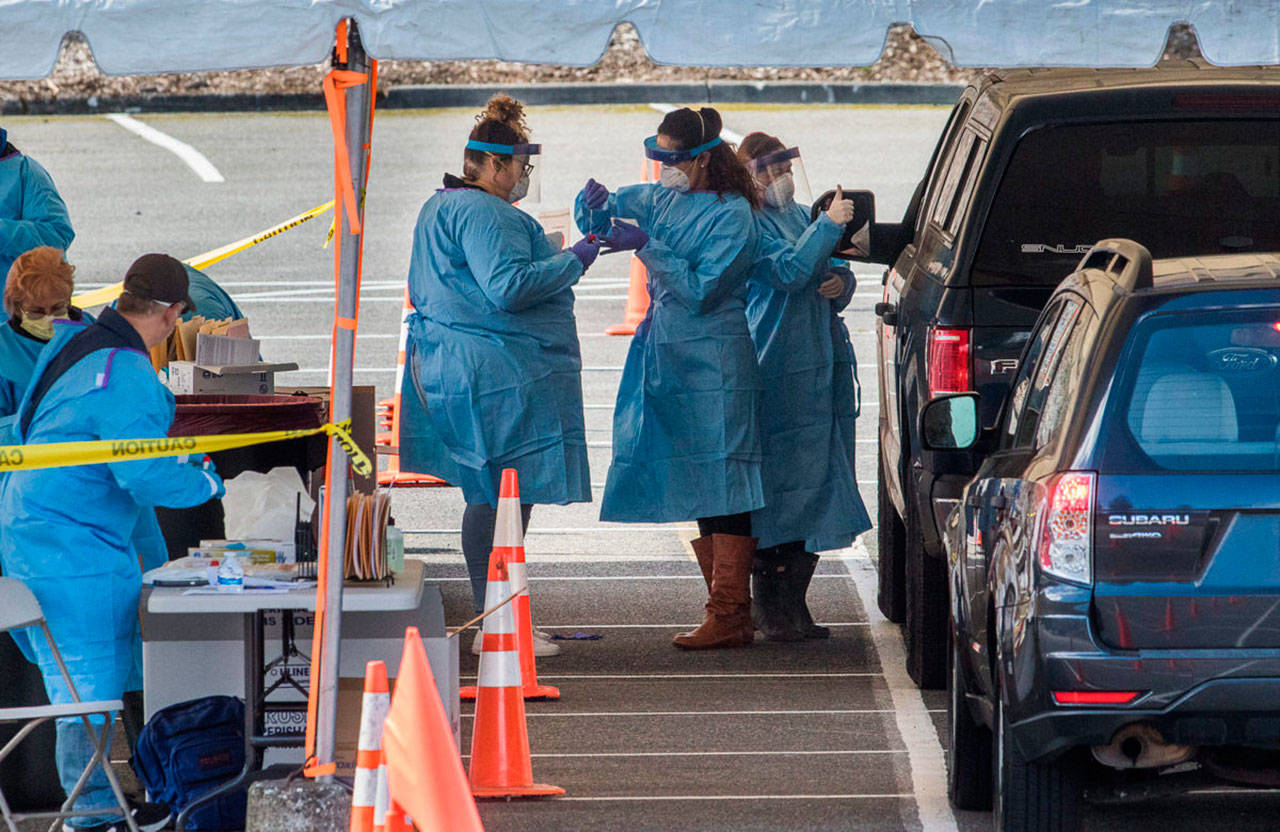 Drive-thru COVID-19 virus testing last week in the parking lot near Everett Memorial Stadium in Everett. A study by the University of Washington and UnitedHealth Group, conducted at Everett Clinic locations, found that a less-intrusive form of the coronavirus test would require fewer precautions by health care workers. (Andy Bronson / The Herald)