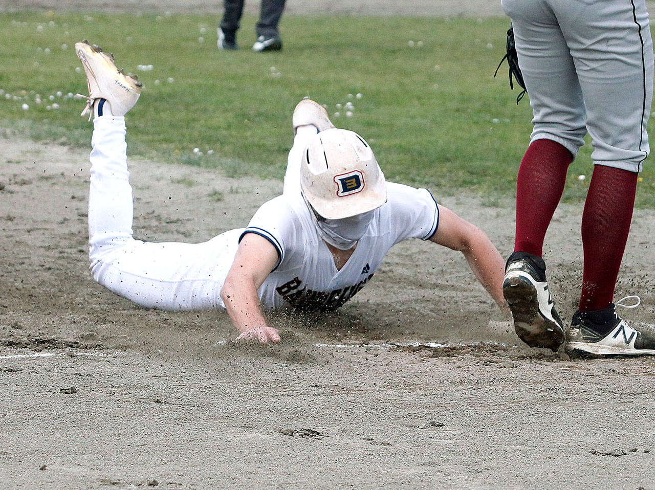 Bainbridge’s JR Ritchie slides into third during the Spartans’ 2021 opener Tuesday against Kingston, a 20-0 route. (Mark Krulish/Bainbridge Island Review photos)