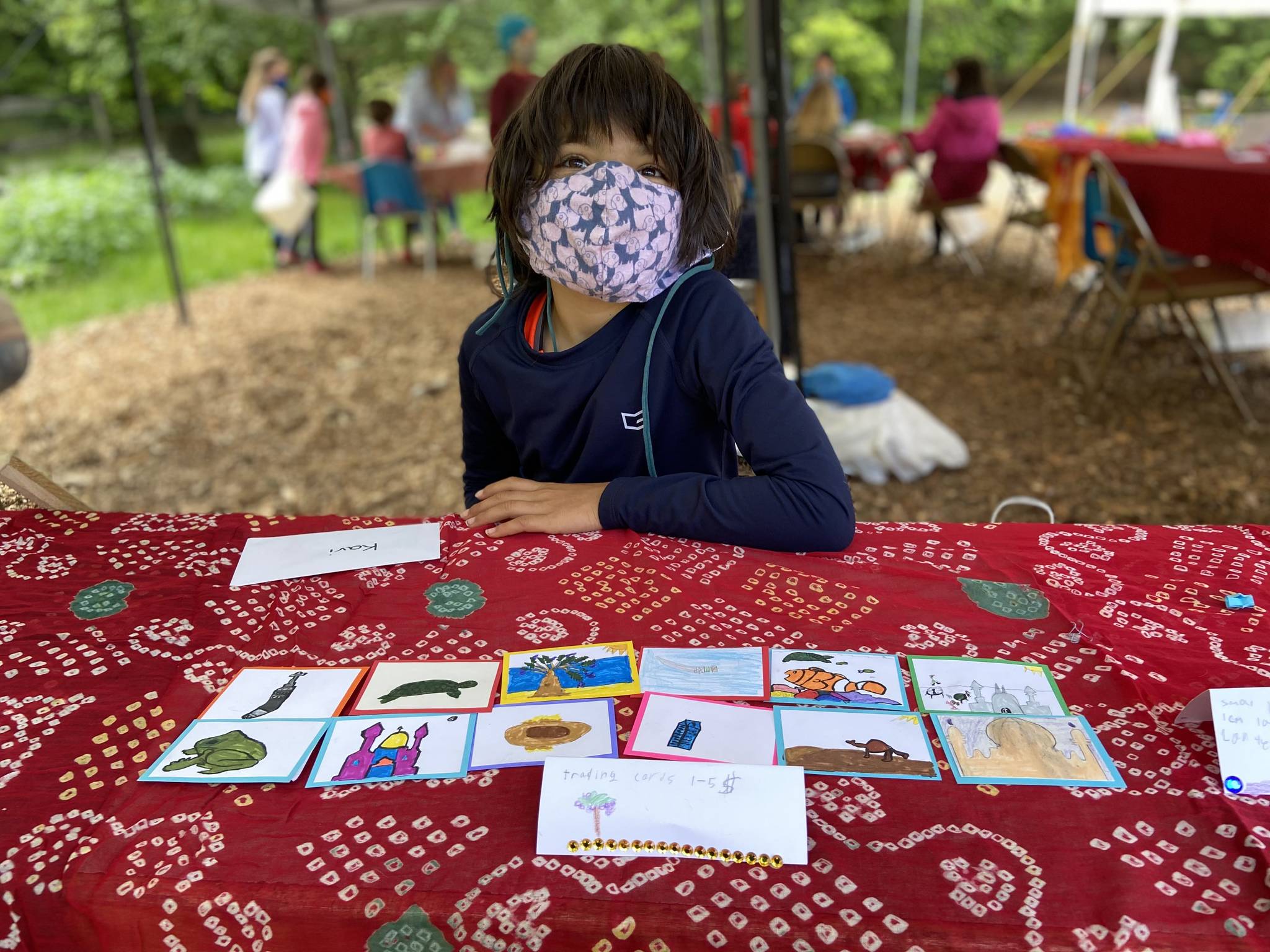 Kavi Danielson, 9, displays trading cards featuring the sea turtles, mosques, palm trees and camels of Oman.