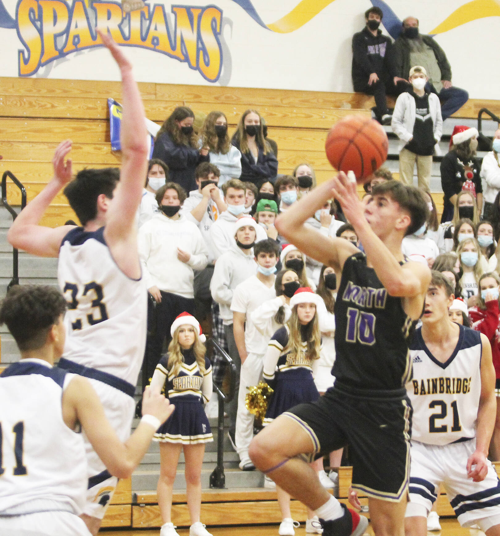 Cade Orness (10) drives to the hoop and puts up a short runner against James Carey (23) of Bainbridge. Breno Oguri (11) and Everett Moore (21) also defend. Steve Powell/Bainbridge Island Review photos