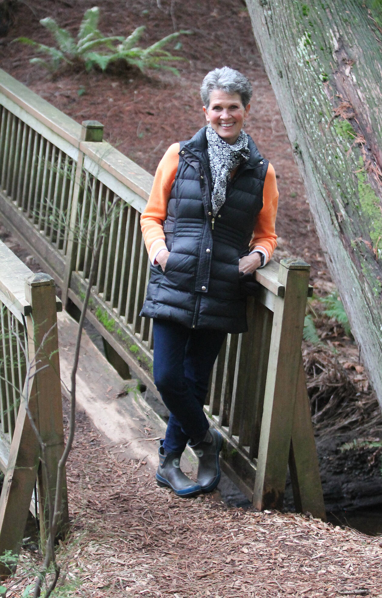 Owner Janice Pedersen at a scenic bridge on the property.