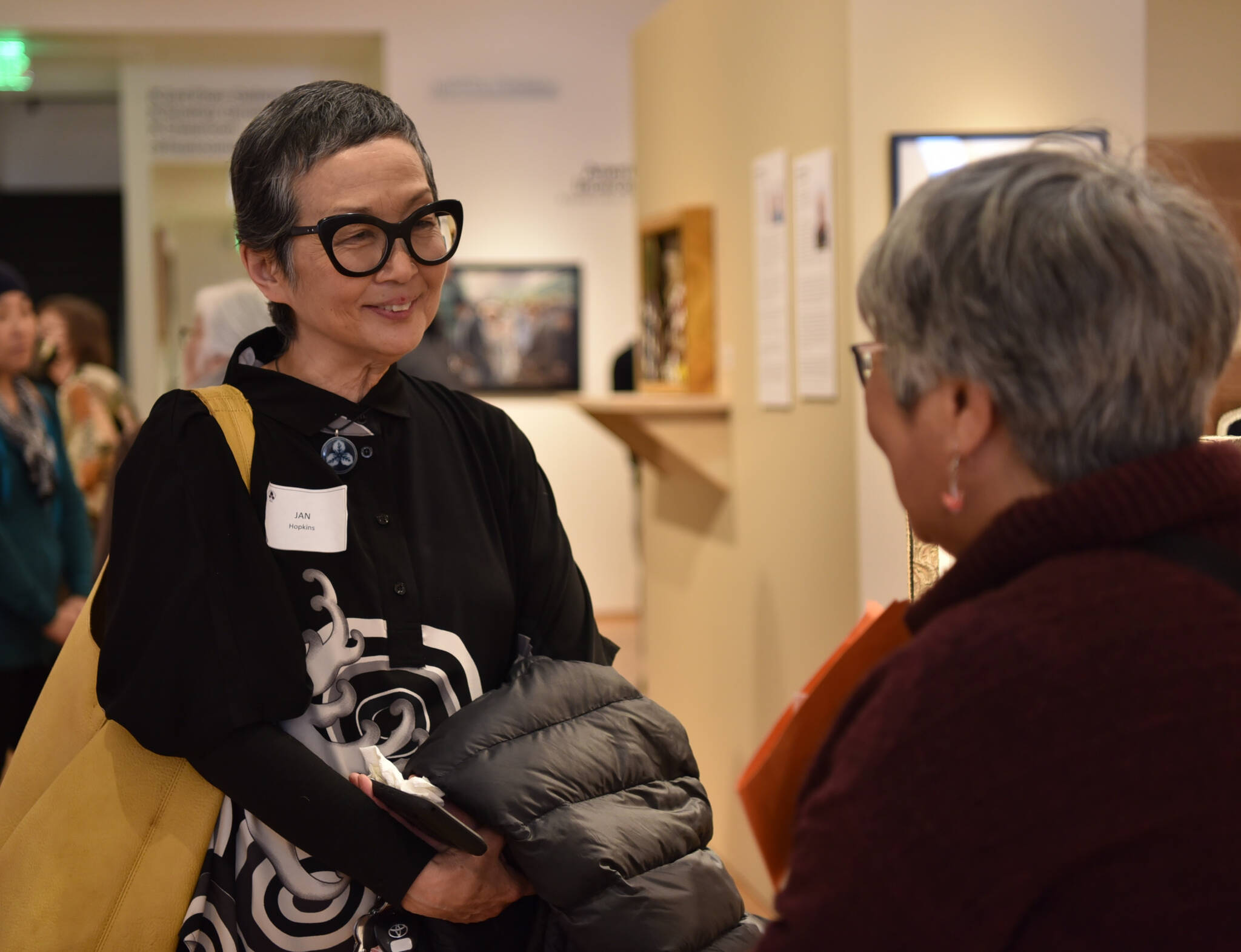 Artist Jan Hopkins speaks with a visitor at Americans Incarcerated: A Family’s Story of Social Injustice exhibit on display at BIMA through June 12.