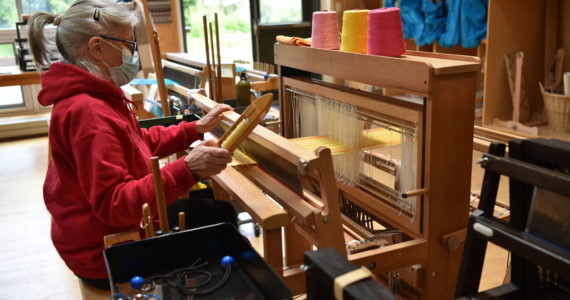 Catherine Camp works at a loom to weave a scarf in the Fiber Arts studio. Nancy Treder/Bainbridge Review photos