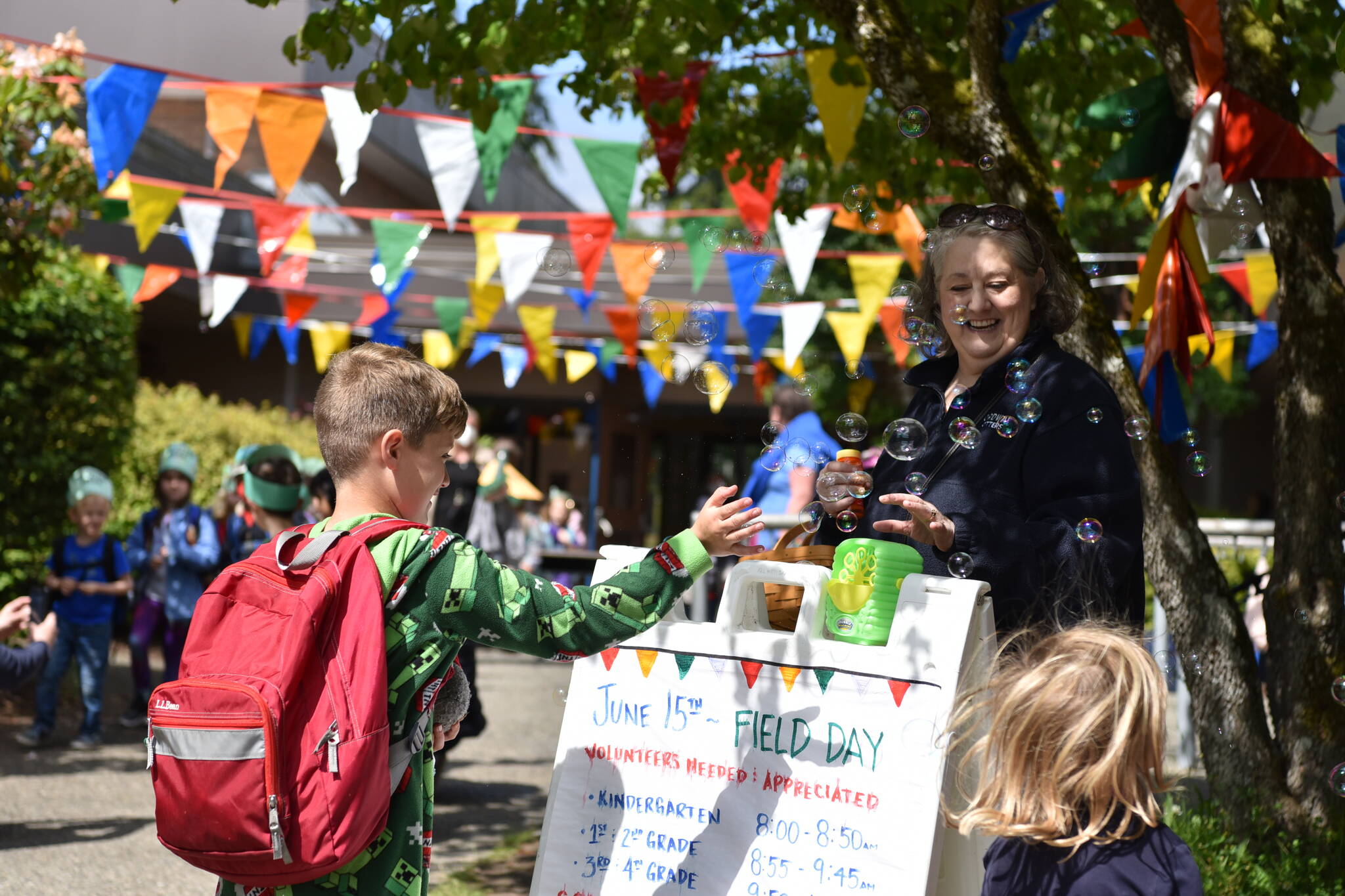 Ordway Elementary School substitute teacher Kathy Dudgeon shares bubbles with kids on the last day of school.