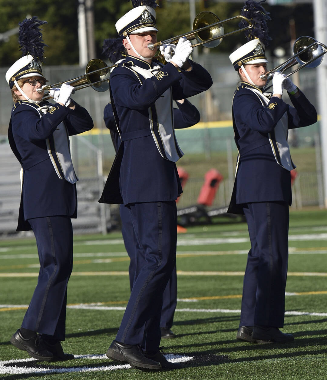 Trombones move in unison on the field.