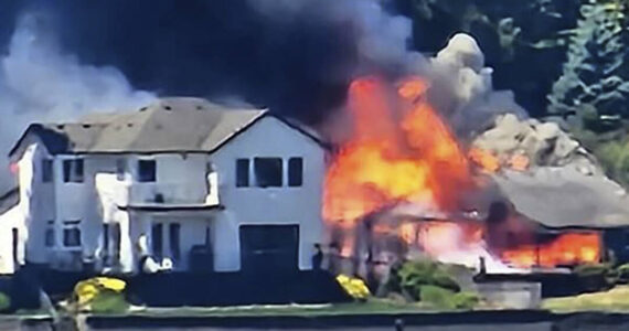 Andrea Powell courtesy photo
Smoke and flames erupt from a three-alarm house fire on Erlands Beach Loop NW.