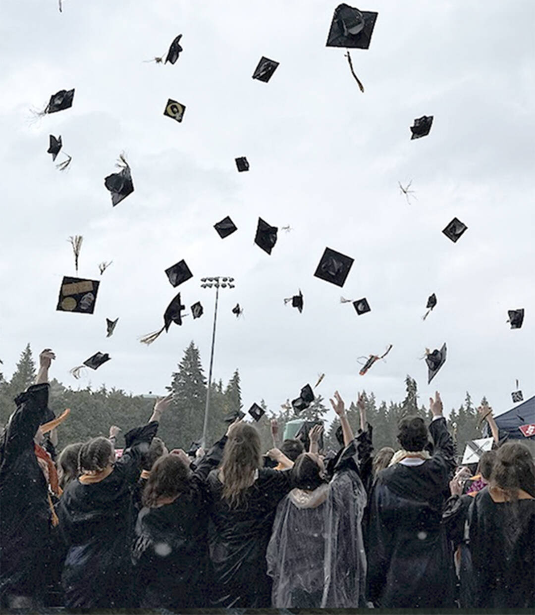 Bainbridge High School graduates toss their caps into the air to celebrate the end of the ceremony.