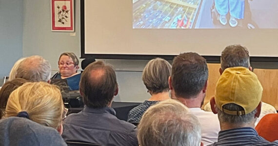 Molly Hetherwick/Kitsap News Group
Karen Braitmayer, left and on screen, talks on Bainbridge about access for people with disabilities.