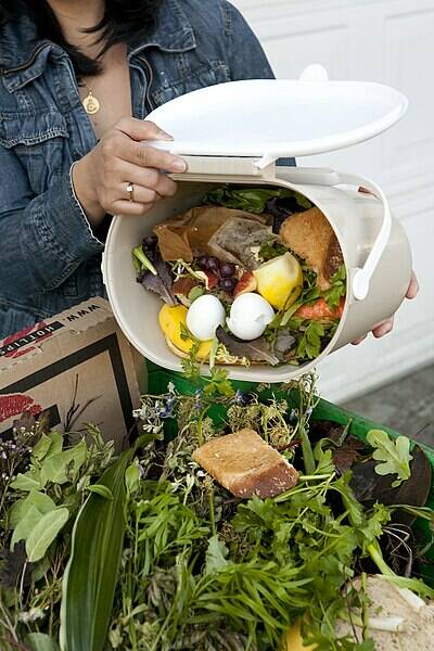 Tim Jewett courtesy photo
A resident adds kitchen food scraps to yard debris in a green bin.