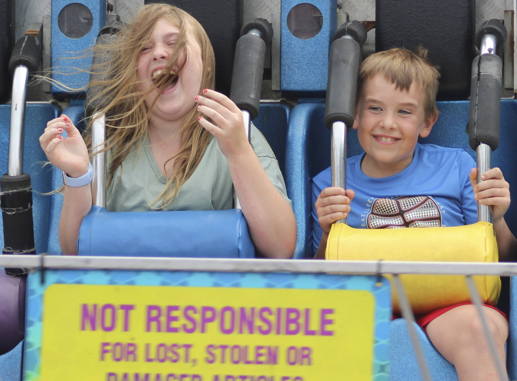 Sofie and Gabe can’t help but scream and hang on during a carnival ride at the Kitsap Fair and Stampede, which runs through Sunday.