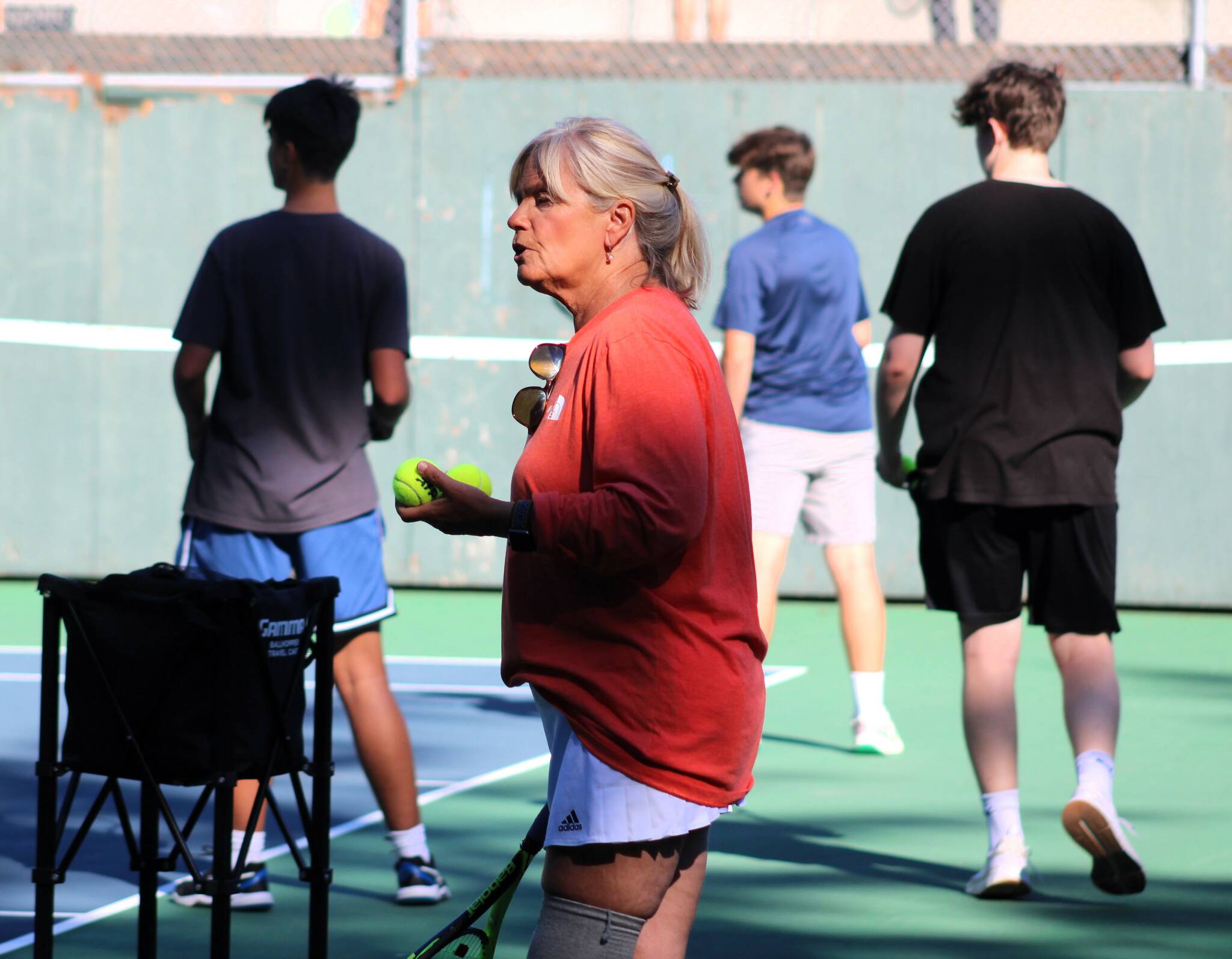 Bainbridge High tennis coach Mary McCombs takes her players through forehand drills in practice.