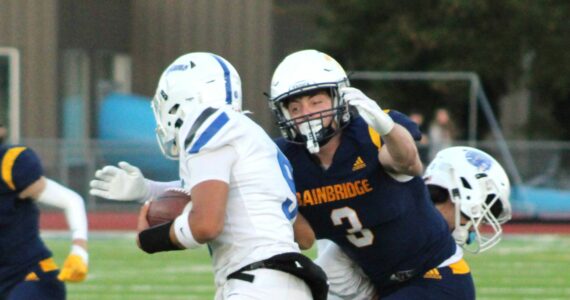 Elisha Meyer/Kitsap News Group photos
Bainbridge senior Adrian Ayling goes in for a tackle against a scrambling Olympic quarterback Antonio Castorena.