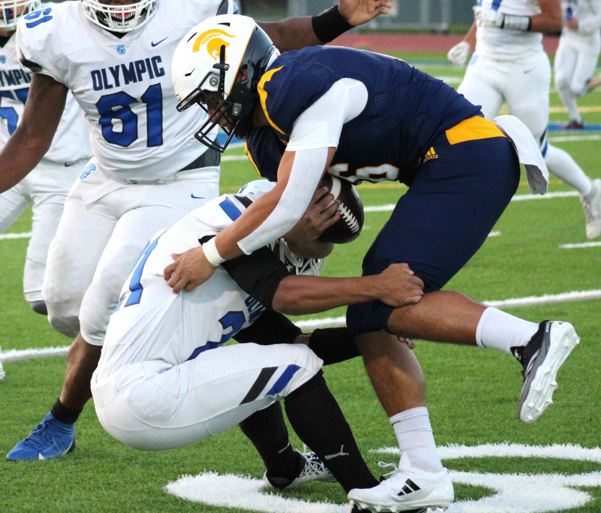 Spartan quarterback Jack Grant braces himself for the hit as he races for a first down against the Olympic Trojans.