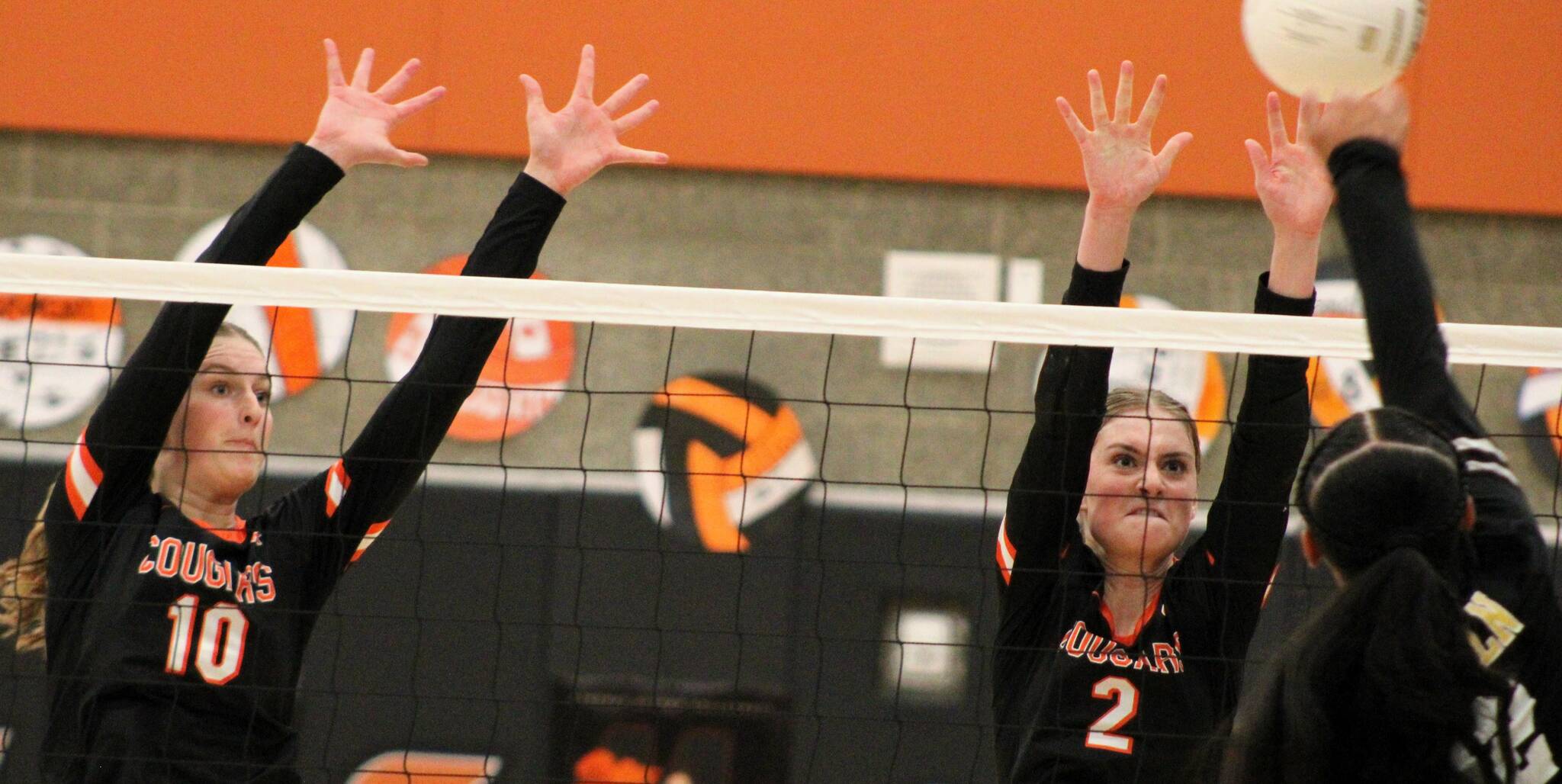 CK sophomore Sydney Lingenbrink, left, and sister Jordan both go up for a block against a Lincoln attacker.