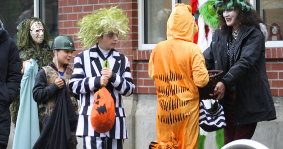 Molly Hetherwick/Kitsap News Group
Hometown Halloween was a big hit on Bainbridge Island Oct. 31, as always. Here, Beetlejuice and Garfield select some candy from a business owner along Winslow Way.