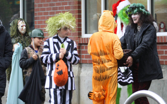 Molly Hetherwick/Kitsap News Group
Hometown Halloween was a big hit on Bainbridge Island Oct. 31, as always. Here, Beetlejuice and Garfield select some candy from a business owner along Winslow Way.