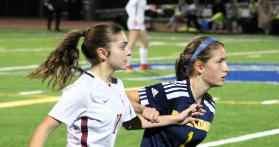 Elisha Meyer/Kitsap News Group photos
Kingston sophomore Emily Kispert and Bainbridge freshman Vega Hendrickson battle for better ground while watching the ball.