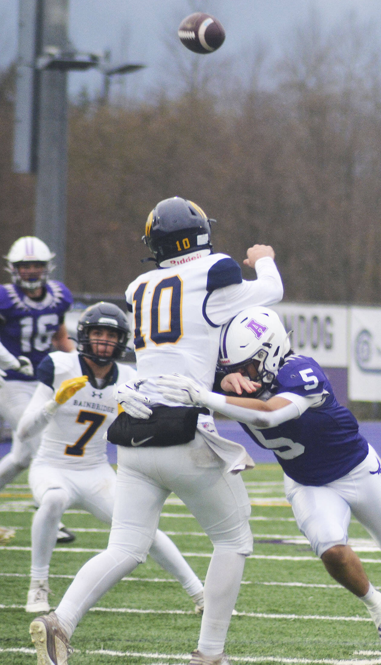 Bainbridge quarterback Nate Putnam (10) gets off a pass just as Miguel Maldonado (5) hits him.