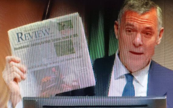 Steve Powell/Kitsap News Group
Bainbridge Mayor Joe Deets holds up the Review showing the top story is about the Highway 305-High School Road roundabout.