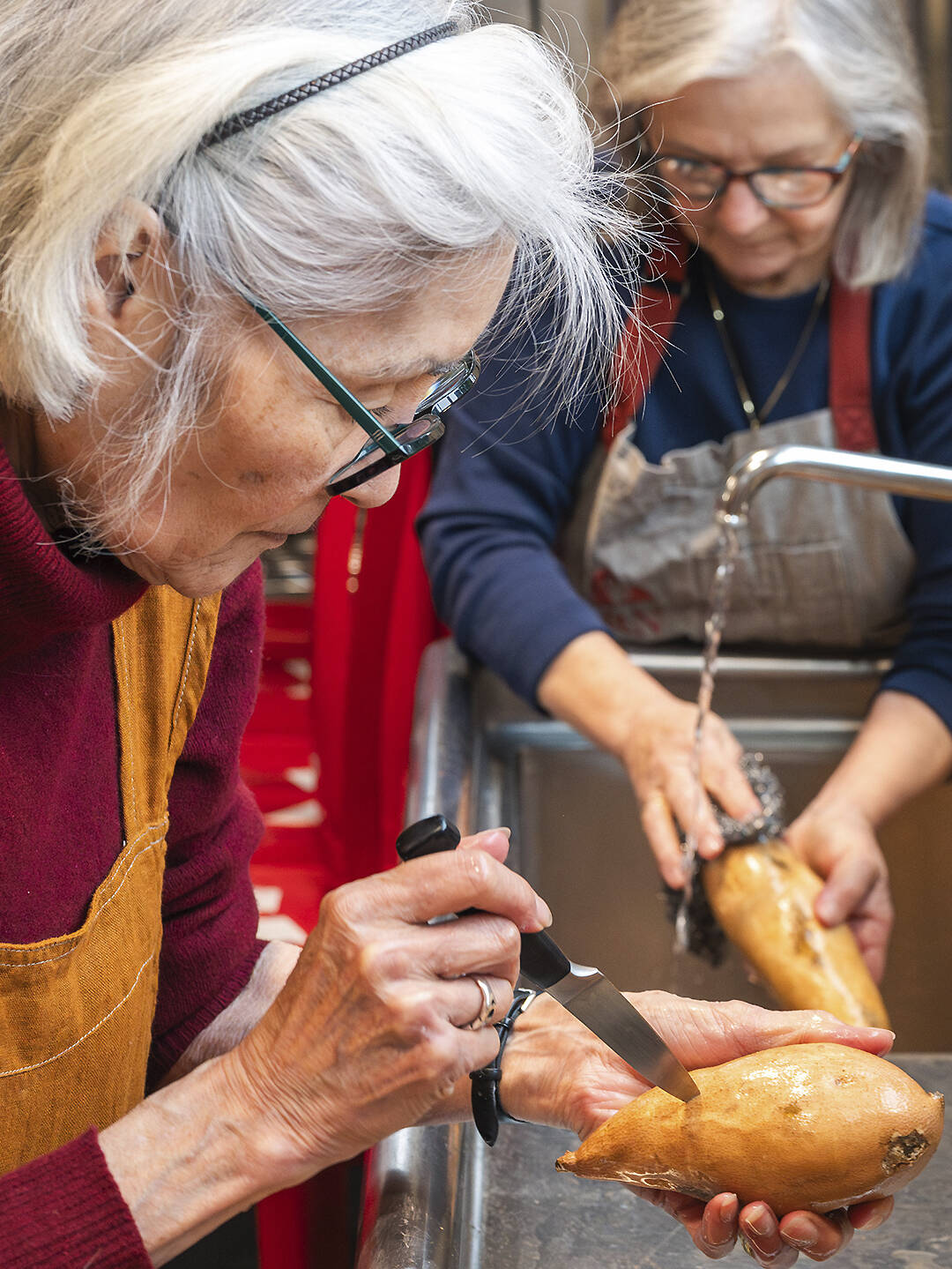 Billee Gearheard, left, and Marcia Adams-Landry cut up potatoes for the folks in need.